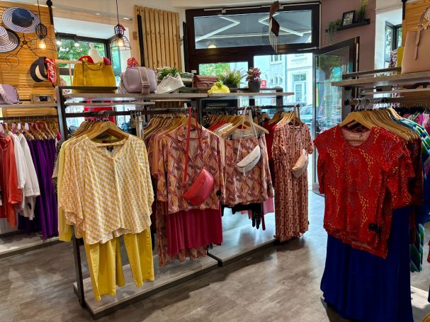 Bunte Damenoberteile und Röcke in einem Modegeschäft ausgestellt.